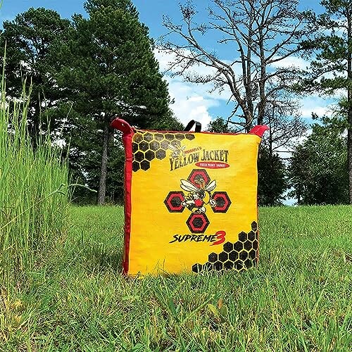 Archery target bag on grassy field with trees in background.