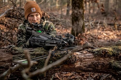 Hunter in camouflage with crossbow in forest